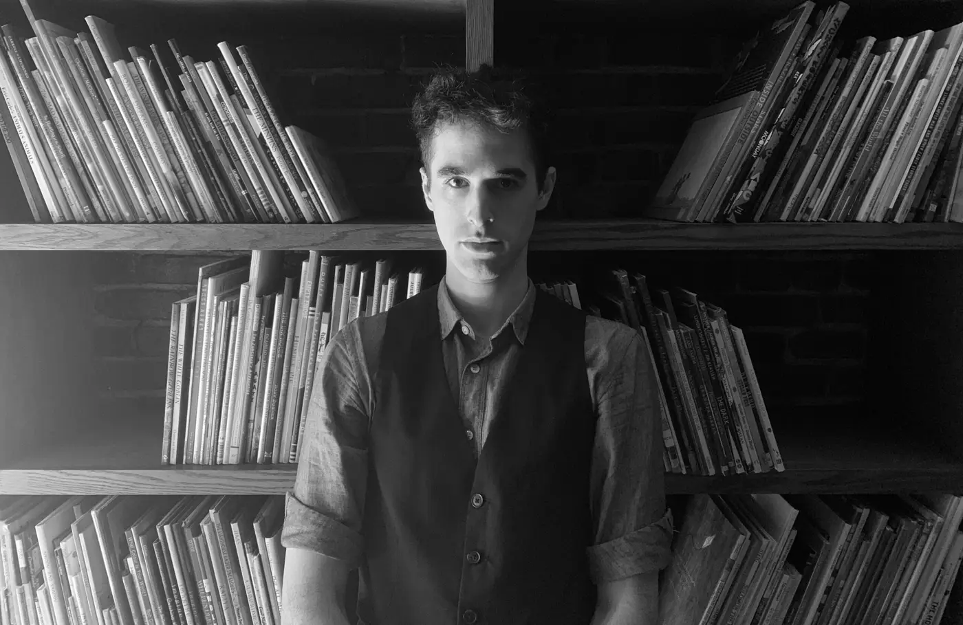 Jonah Dragan in front of shelves of picture books